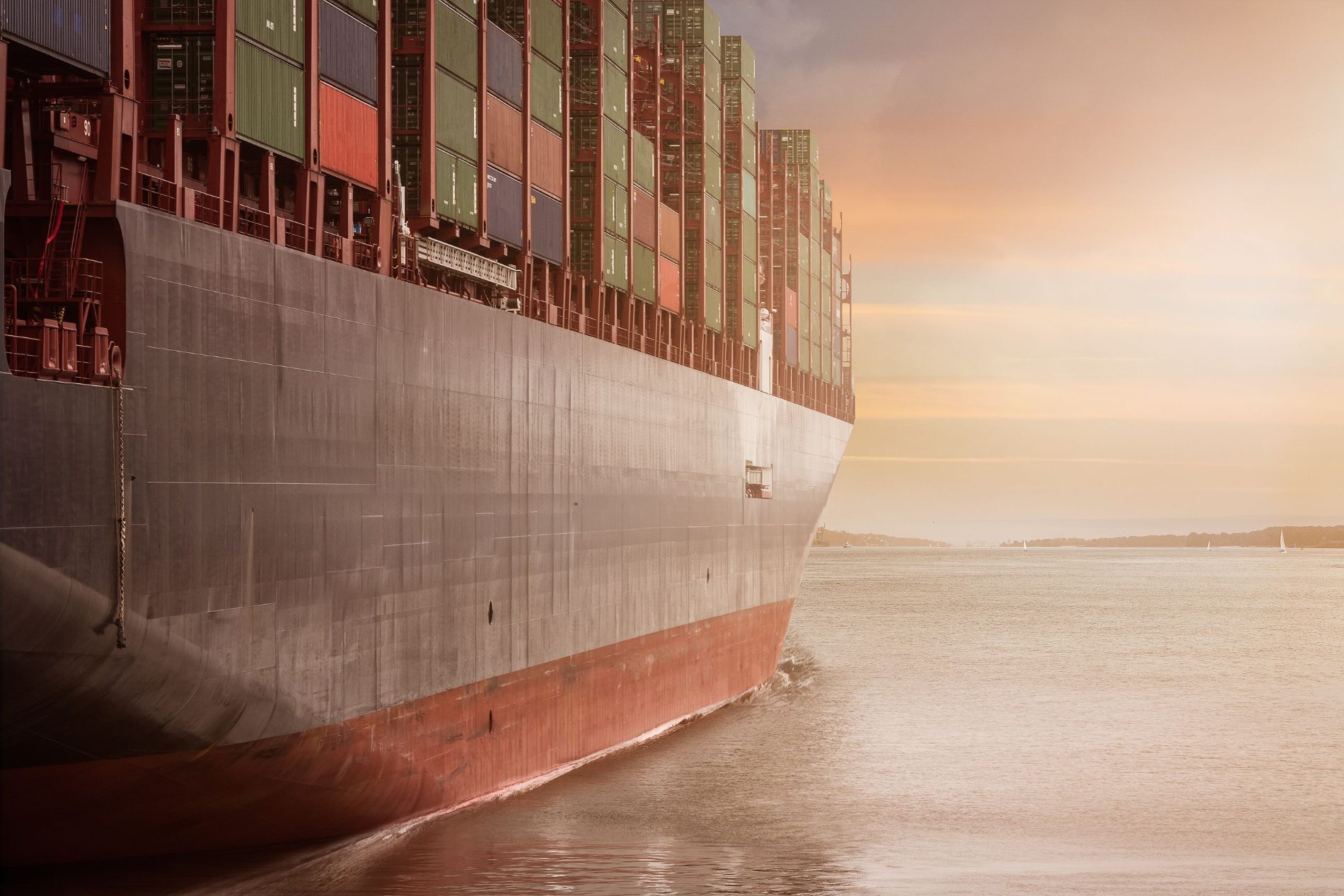 A container ship on open water at dusk